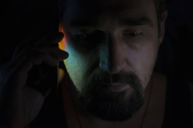 Odanın Karanlığında Akıllı Telefon Üzerinden Konuşan Sakallı Adam