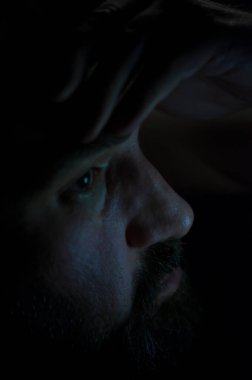 Karanlık odada sakal olan depresif adam. Sorunlar, anksiyete, üzüntü kavramı.