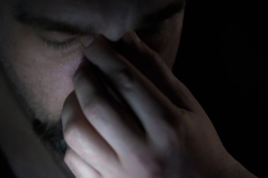 Karanlık odada sakal olan depresif adam. Sorunlar, anksiyete, üzüntü kavramı.