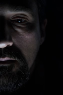 Karanlık odada sakal olan depresif adam. Sorunlar, anksiyete, üzüntü kavramı.