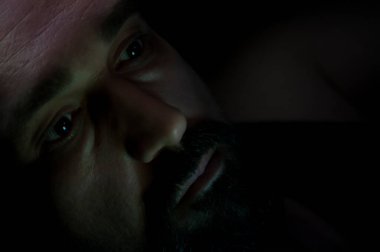 Karanlık odada sakal olan depresif adam. Sorunlar, anksiyete, üzüntü kavramı.