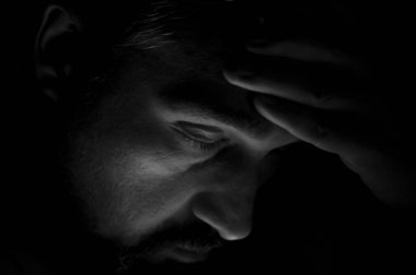 Karanlık odada sakal olan depresif adam. Sorunlar, anksiyete, üzüntü kavramı.