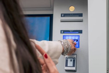Atm'de kredi kartını kullanan kadın elin yakın çekim görünümü