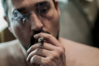 Ağızda yanan puro ile adam profilinde Closeup yüz.