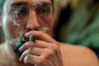 Ağızda yanan puro ile adam profilinde Closeup yüz.