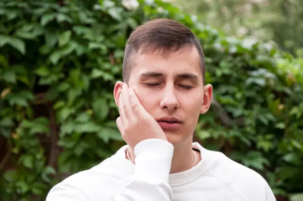 Park genç yakışıklı adam portre diş ağrısı ile ilgili sorunlar yaşıyorsanız