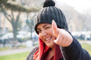 Parkta başparmak ile yünlü şapka ile Çekici genç redhead