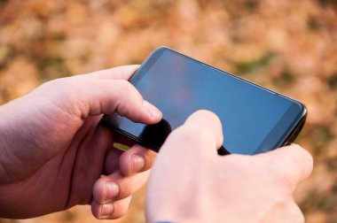 Açık havada metin mesajı yazarak erkek elleri görünümü yakın