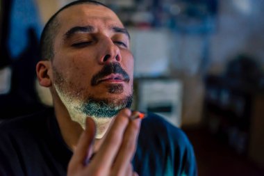 Esrar içen sakallı bir adamın profili. Yakın plan. 