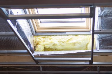 Mansard Garret 'a ya da tavan arasına tavan penceresi takmak. Askıya alınmış tavanlar, termal yalıtım, buhar geçirgen folyo. Çatı ve pencere ustası işi.