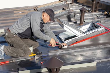 Mansard tavan arası pencereli yeni çatı katı, ya da tavan arası. Roofer tavan penceresi kuruyor. Çatı ustası ve pencere ustası işi. Çatı havalandırma boru sistemi. İnşaat konsepti altında ev geliştirme