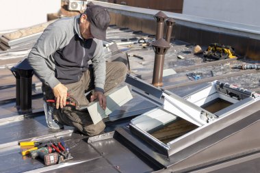 Mansard tavan arası pencereli yeni çatı katı, ya da tavan arası. Roofer tavan penceresi kuruyor. Çatı ustası ve pencere ustası işi. Çatı havalandırma boru sistemi. İnşaat konsepti altında ev geliştirme