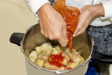 Woman's  hands cooking traditional dish and adding seasoning in a freeze motion. A preparing a delicious meal. clipart