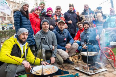 Kragujevac, Sırbistan - Erkekler öğrenci protestoları sırasında yemek hazırlıyorlar. Açık ateşte bir kazanda fasulye kebabı pişirmek. Güveç tenceresinde geleneksel yemek pişirme. Gulaş, açık havada yapılıyor..