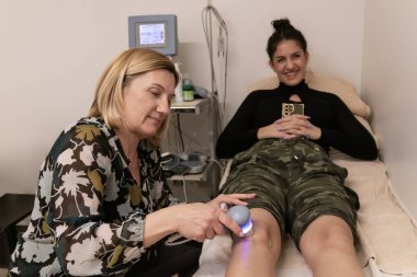 Diz yaralanmalarının fizyoterapisti ve sinirlerin ultrason makinesi ve jel terapisi sağlık ve tıp konseptiyle tedavi yöntemi. Fizyoterapi tekniği..