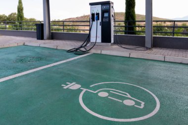 Elektrikli araba şarj tabelaları ve elektrikli araçlar için şarj noktaları. EV şarj istasyonu, temiz enerji dolum teknolojisi, elektrikli araba şarjı. Yedek yakıt.. 