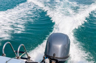 Motorlu teknenin arkasında suda bir iz var. Denizde bir tekne motoru ve arkasında dalgalar..