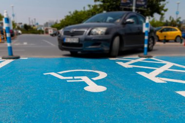 Bir araba, sadece engelliler için özel park yeri olan asfalt park yerinde engelli işareti olan bir yere park edilmiştir. Engelliler için ulaşım kolaylığı