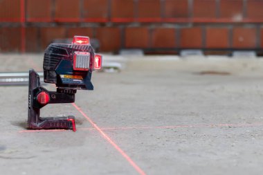 İnşaat alanında tam seviyeyi ayarlamak için lazer seviyesi. İnşaat işleri için modern araçlar.
