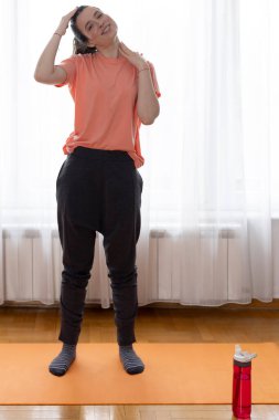 Evdeki odada egzersiz yapan zinde bir genç kadın. Spor, spor ve sağlıklı yaşam tarzı konsepti