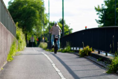 Şehirde bisiklet yolunda bisiklete binen biri. Bisikletçiler için ayrı şerit. Özgürlük ve macera kavramı, adamın dışarıda gezmekten hoşlanması gibi.