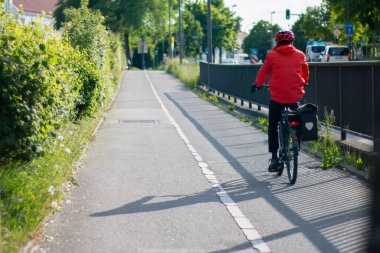 Şehirde bisiklet yolunda bisiklete binen biri. Bisikletçiler için ayrı şerit. Özgürlük ve macera kavramı, adamın dışarıda gezmekten hoşlanması gibi.