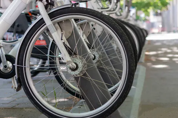 Caddedeki şehir merkezindeki otoparkta kiralık elektrikli bisikletler yeşildir. Çevre dostu ulaşım aracı. Tekerleklere dikkatle odaklan..