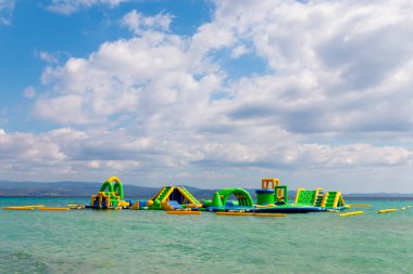 Denizdeki şişirilebilir su parkı manzarası. Çocuklar için eğlence parkı. Deniz manzaralı Aquapark 'ın cazibesi.