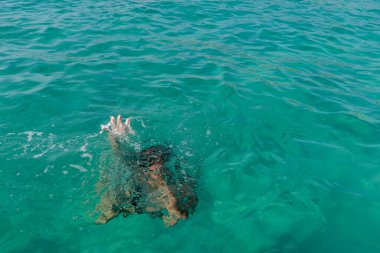 Kaldırılmış ellerle boğulan kadın. Suda boğulan kişi sudan çıkmış..