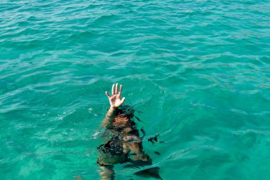 Kaldırılmış ellerle boğulan kadın. Suda boğulan kişi sudan çıkmış..