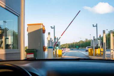 Otoyol parasını ödemek için kontrol noktasından geçen bir araba. Otoyol ya da otoyolu kullanmak için gişede kartla ödeme yapan adam..