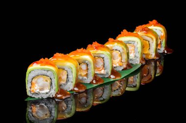 a set of Japanese California sushi rolls with shrimp, Philadelphia cheese, red flying fish caviar and avocado. close-up on a black background 