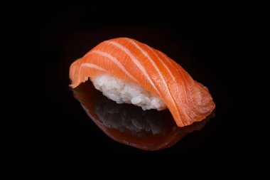 classic sushi with salmon on a black background with reflection 