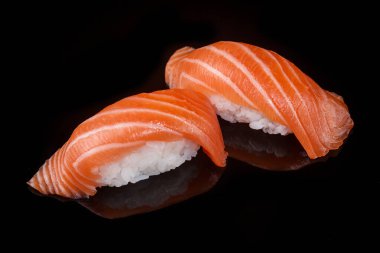 classic sushi with salmon on a black background with reflection 
