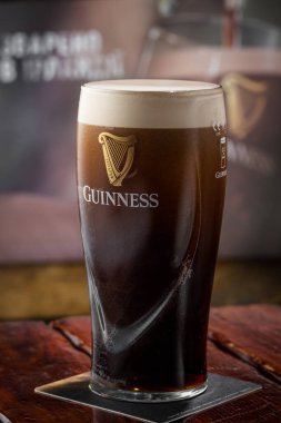 Kyiv, Ukrayna - 12 Nisan 2023: Bardakta Guinness yazan ünlü siyah siyah İrlanda birası. 