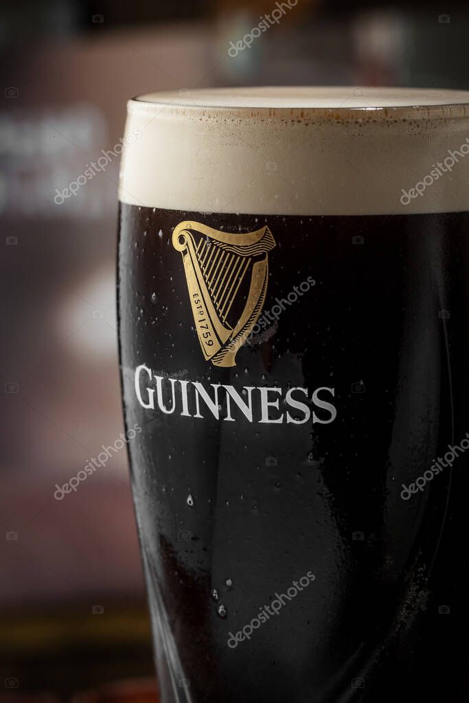 Kyiv, Ukraine - April 12, 2023: The famous original black dark Irish beer Guinness in a glass with the inscription Guinness