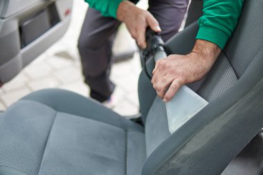 Araba temizleme - erkek profesyonel buhar süpürgesi kullanıyor. Kirli araba koltukları için kimyasal temizlik ve çıkartma metodu.