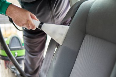 Araba temizleme - erkek profesyonel buhar süpürgesi kullanıyor. Kirli araba koltukları için kimyasal temizlik ve çıkartma metodu.