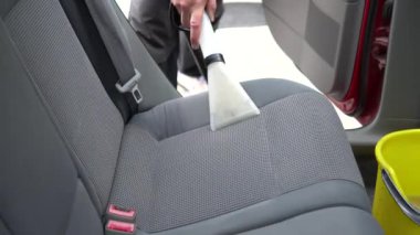Araba temizleme - erkek profesyonel buhar süpürgesi kullanıyor. Kirli araba koltukları için kimyasal temizlik ve çıkartma metodu.