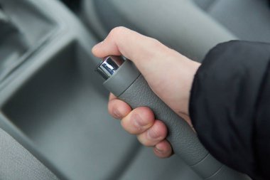 El frenini çeken, el frenini çeken, gri arabanın içindeki el frenini çeken adam.