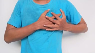 Mavi gömlekli adamın elleri Beyaz arka planda acı dolu göğsü sıkıyor
