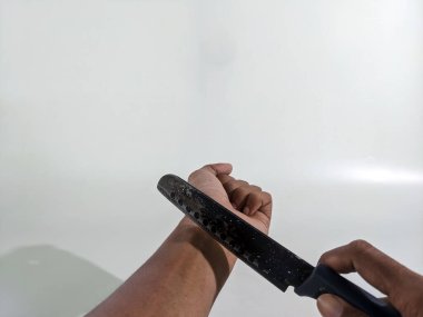 Bıçak tutan bir el. Beyaz arka planda izole edilmiş. İnsanların et keserken çekilmiş fotoğrafları.