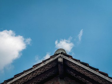 Arka planda güzel mavi gökyüzü olan yıpranmış bir evin çatısı.