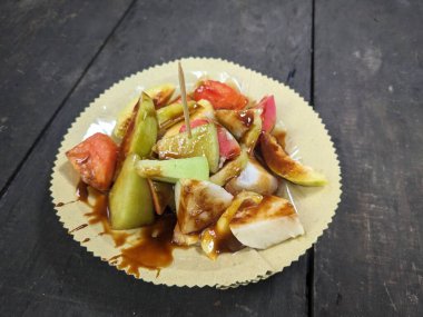 Rojak, Endonezya 'da sıkça bulunan bir meyve salatası türüdür ve üzeri sıvı kahverengi şekerle kaplıdır.