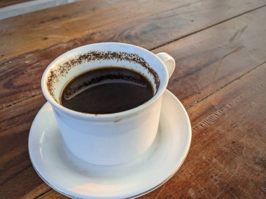 Beyaz seramik kahve. Tahta masa, kafe, fotokopi alanı.