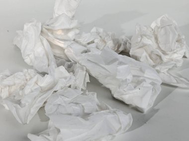 Kullanılmış dokular beyaz masaya saçılmış.