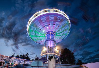 Bulutlu bir gökyüzü ile gece bir karnaval gezisi