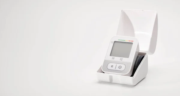 stock image Tonometer, automatic digital blood pressure monitor on the wrist, lying on the table, pressure diagnosis, on a white background, place for text, banner