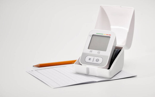 Автоматический цифровой монитор артериального давления запястья, график контроля давления, карандаш, на белом фоне