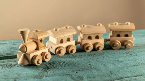A children\'s wooden toy, a steam engine, on a wooden background